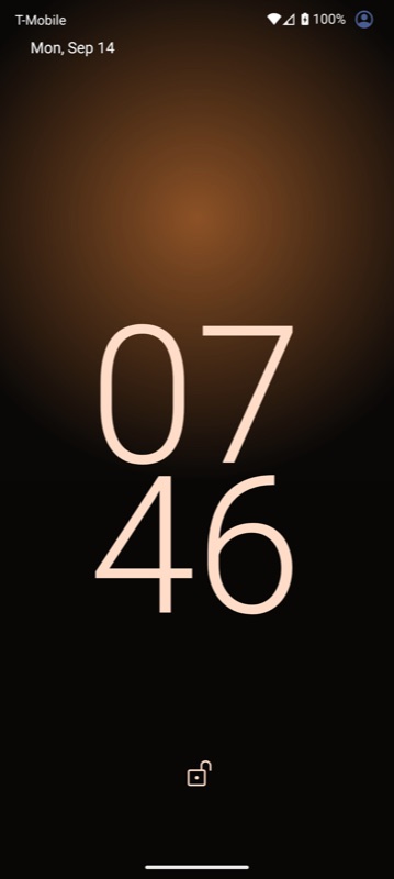 An Android lock screen showing the warm amber wallpaper edge to edge behind the clock.